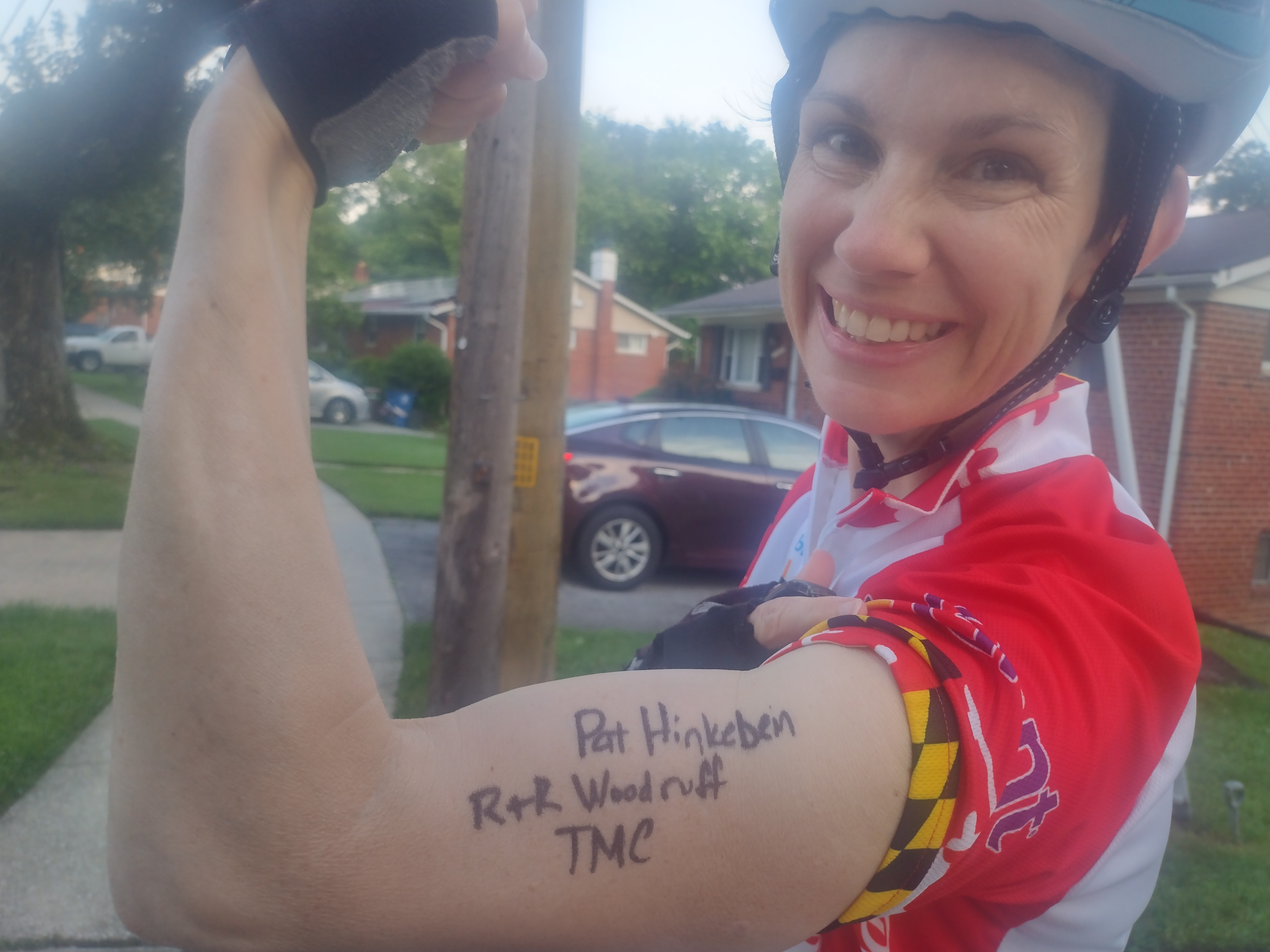 Woman with her arm up with the names Pat Hinkebein, R+R Woodruff, and TMC written on the biceps
