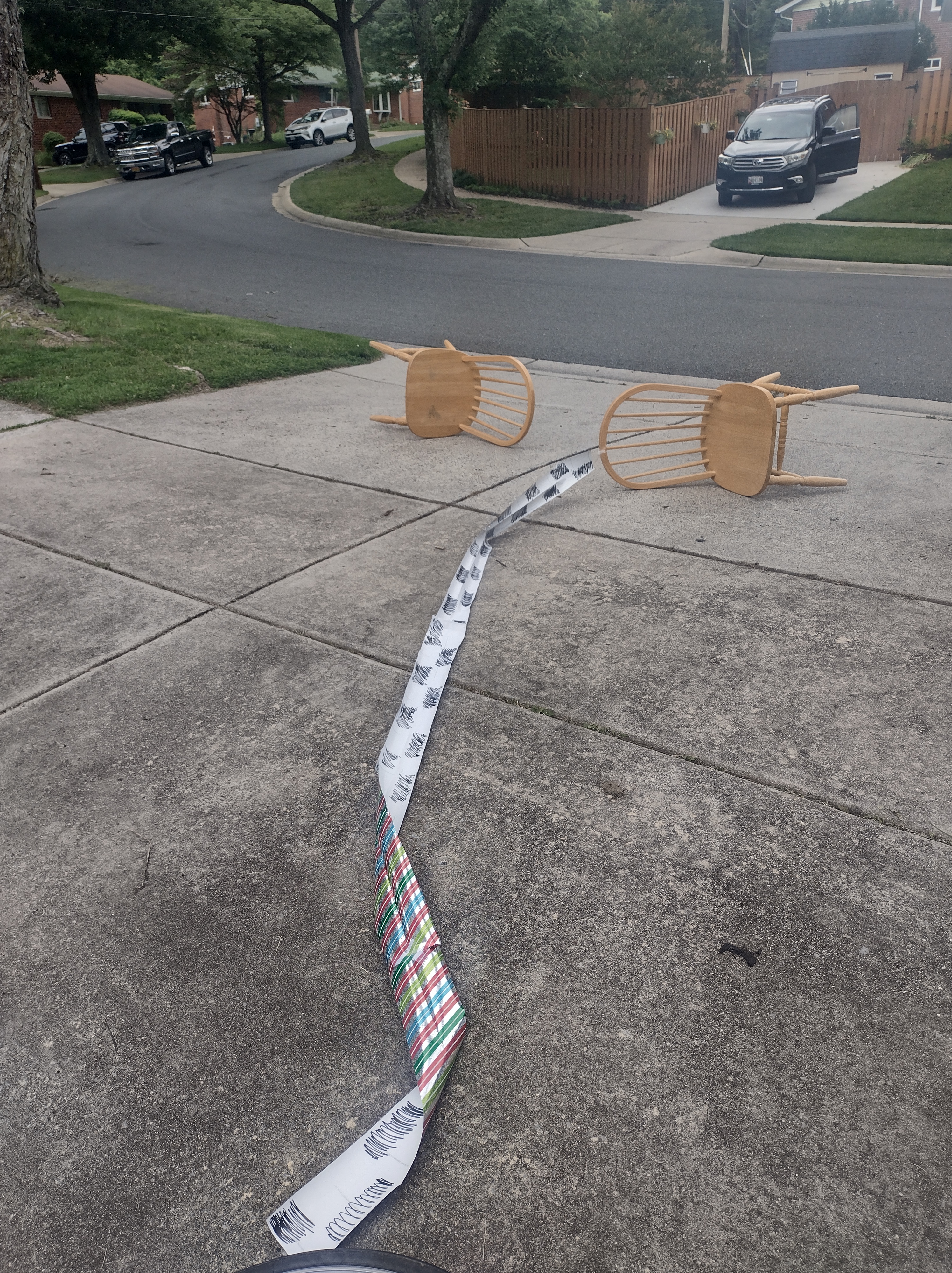 Two wooden chairs on their sides, the streamer from the first picture now lying on the ground